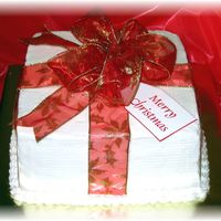 Christmas Present Wrapped In Red Ribbon 9" square iced in buttercream with red fabric ribbon and bow.