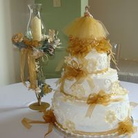 136.jpg 3 tier cake 14-10-6 with buttercream icing. The flowers were made with fondant and dusted with gold luster.