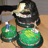 Dragon And Wizard Birthday Cake 6" Red Velvet, 8" Milk Chocolate, and 10" White cakes, iced in buttercream with royal icing and gumpaste accents.