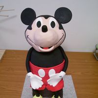 Mickey Mouse Head made w/RKTs and covered in fondant. Body made in a Pyrex bowl and 2 7" rounds. Mickey is sitting on a box made of cake. Arms,...