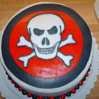 Skull Cake half chocolate half white cake, butter cream filling with all vanilla buttercream icing all decorations are done out of fondant.