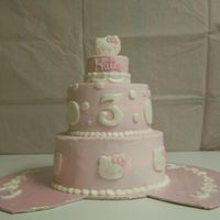 Hello Kitty 12" 6" and 2" layer cakes iced w/buttercream. Fondant hello kitty made with cookie cutter and bow border covered in pearl...