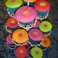 Exotic Cupcakes Late night treat, chocolate fudge cupcakes decorated in brightly coloured fondant, daisy cutouts.