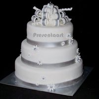 White With Silver Wedding Cake Covered with fondant, and decorations (bow, band and flowers) also made of fondant with lustre dust.