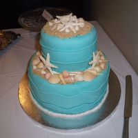 Kevin & Sarah's Engagement Party Cake Cake is 6" freckled mocha w/kahlua cream filling and 10" WASC w/raspberry filling. Shells are chocolate, starfish are gumpaste.