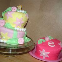 First Birthday Girl Cake Birthday cake covered in buttercream and decorated with pastel fondant. The smash cake is covered in buttercream.