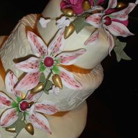 Lillies, Wine And Gold Fondant covered cake. Gumpaste flowers. I used textured rolling pin on the fondant
