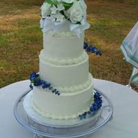 First Wedding Cake Buttercream icing, top is a Wilton Gumpaste Topper and blue flowers are artificial.