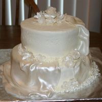 Small White Wedding Cake Frosted in buttercream fondant flowers and drapes painted with pearl dust.