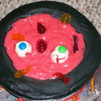 Cauldron Cake Cake is devil's food with bc frosting. The "blood" is red colored white chocolate pudding. Cake ball eyes, pretzel wood, and...