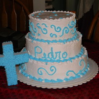 Baptism Cake tres leches cake with coconut filling in the bottom two layers. The top cake is a flan cake. It is decorated with whip topping.