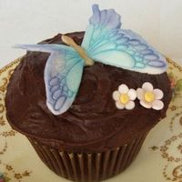 Butterfly Chocolate Cupcake Dense chocolate cupcake with fudge icing. Gumpaste butterfly and flowers coloured using luster dusts.