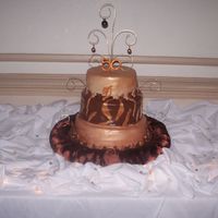 50Th Birthday Chocolate and Gold colored cake. 1st and 3rd layers are covered in lemon flavored fondant but sprayed with copper and goldsparkle dust. The...