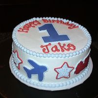 Airplanes And Firetrucks made for a little boy turning one. white cake with buttercream icing. Fondant #1, airplanes and firetrucks. Stars are buttercream.