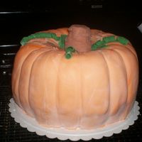 Pumpkin Cake 2 Bundt cakes put together, iced in buttercream covered in Satin Ice Fondant Fondant accents, stem is ice cream cone.