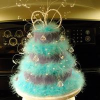 Feather And Jewel Cake 3 tier ( 4, 6 & 8) covered in purple fondant. decorated with teal feathers and jewels. Peanut butter cake with fudge filling