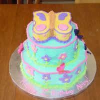 First Birthday This was a cake for a one year old with a flower and butterfly theme. The cakes were covered with buttercream with Fondant flowers. The...