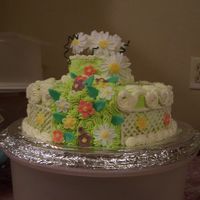 Daisy i made this for my mom on mothers day i call it my daisy cake ,its made with buttercream icing and fandant flowers and the fence is white...