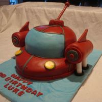 Little Einstein Rocket Used a 12" round pan for the bottom layer and the soccer ball pan for the top. Carved out the bottom and covered in fondant. Used rice...