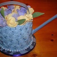 Mother's Day Watering Can Cake Lemon chiffon cake raspberry filled. Fondant and gum paste decorations. The board is also covered in fondant to replicate a stone path....