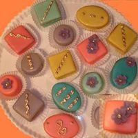 Petit Fours Almond Joconde Sponge, marzipan and tinted colored fondant glaze. Apricot and berry fillings. Royal icing and marzipan flowers decoration...