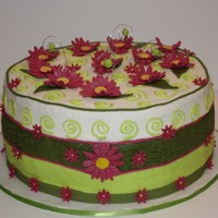 Daisy Garden French Vanilla cake iced in cream cheese icing. Fondant ribbon, gumpaste daisies. They are supposed to be fuchsia, but I am not sure the...