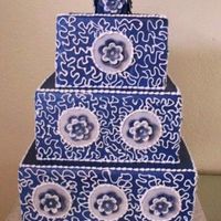 Blue Squares 3 tier wedding cake (dummy) Covered in fondant and air brushed blue. Piped royal conrelli lace with fondant blue and white flowers.