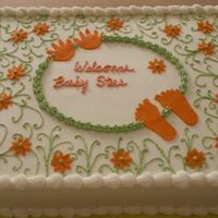 Baby Shower For Steer Double layer half sheet cake. Iced in buttercream with green scrolls and orange fondant daisy's feet and hands.