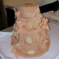 Large Lily Flowers White cake covered in Fondant with Fondant Lily-type flowers. Cake was not completed with topper as reception hall insisted they had to...