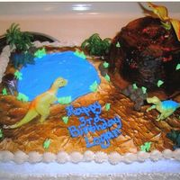 Dino Land This is a white sheetcake with a chocolate volcano. Buttercream iced and I used gel for the lake and lava. I also used plastic dino pieces...