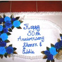 Blue Roses Anniversary Cake white cake with buttercream frosting with buttercream roses and gold foil leafs