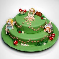 Three Little Fairies Two tiers cake covered with rolled fondant.The little fairies, mushrooms, ladybugs, and log were handmade with sugar paste.