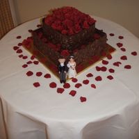 Chocolate Wedding Cake Yummy 2 tier choc mud cake iced with ganache with a solid chocolate embossed wrap around both tiers, roses and petals I made from gumpaste...