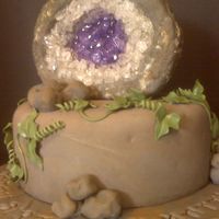 3_1247936884.jpg Cake for a coworker's boyfriend. He is a geologist and she wanted a "rock cake." Amythest geode is RKT covered in fondant...