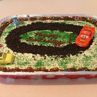 Lightning Mcqueen Yellow cake. Small toys from store. Race track is crushed up oreos. Made for a friends young son.