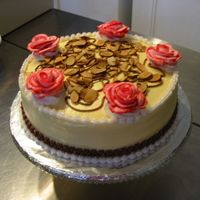 Almond Slice Cake Yellow buttercream base. Roses done with bag-striping.Almond slices scattered over top.