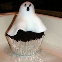 Ghost Cupcake Halloween cupcake, yellow cake with chocolate icing. Oreo's for dirt. Ghost made from dum dum lollipop covered in fondant.