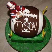 Football Baby this is a 1st birthday cake for the son of a football fan. The baby figurine was hand formed, and the cakes were carved. It was fun to make...