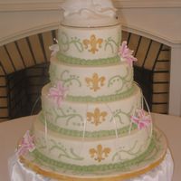 Gold Fluer De Lis The bride is from Louisiana and wanted to have a fluer de lis on her cake. I painted it on with gold luster dust mixed with clear vanilla....