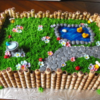 Spring Garden Buttercream grass, fondant decorations, piping gel pond, cookie fence. I have a lot of fun making this for a special 1 year old!