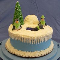 Winter Penguins 8" round two-layer with buttercream icing. Penguins are made out of gumpaste. Tree is ice cream cone with green icing piped on with...