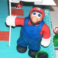 Close Up Of Fondant Mario Mario is made of scrunched foil covered with Fondant. The flag with the banner and the sticks that are in his legs are what anchor him to...