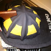 Firefighter Helmet Cake The "brim" of the hat is cardboard covered in fondant and the bronze helmet patch/shield is fondant w/ Tylos covering card stock...