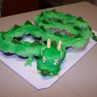 Cupake Dragon Cupcake cake for a Chinese themed birthday. The dragon is covered in buttercream frosting and MMF. The head was sculpted by stacking...