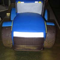Tractor 3D sculpted New Holland grooms cake Covered in fondant. Tires are rice krispies covered in fondant.