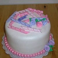 Pink Is Pretty 8'' round cake covered in satin ice & dusted with luster dust. Hand made pink pearls on the bottom, curly q's on top and...