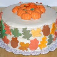 Happy Thanksgiving White cake w/ buttercream frosting. Satin Ice leaves and acorns, choc. pumpkins on top of cake. (oops, buttercream was a bit "runny.&...