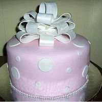 Polka Dot Cake White cake w/ choc. pudding filling. Covered in Satin Ice w/ circles "polka dots." Pearls boarder and bow completes cake.