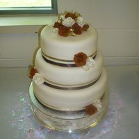 Brown/gold Shower All flowers are gumpaste. Satin ribbons. Lemon pound cake with strawberry filling covered in fondant.