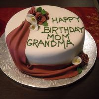 80Th Birthday Cake White cake covered in fondant with fondant drapes and flowers.